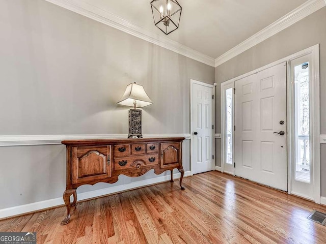 foyer entrance featuring baseboards, crown molding, and a wealth of natural light