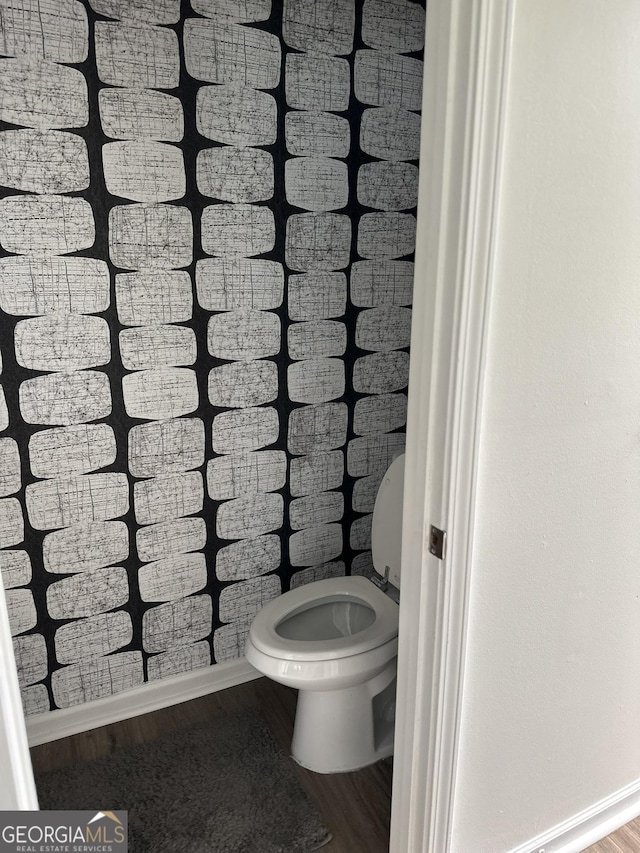 bathroom featuring baseboards, toilet, and wood finished floors