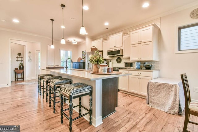 5641 Tisbury Ct, Hoschton, GA 30548 - kitchen with light countertops, decorative backsplash, stainless steel microwave, and ornamental molding