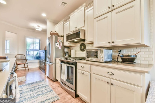 5641 Tisbury Ct, Hoschton, GA 30548 - kitchen with visible vents, appliances with stainless steel finishes, light countertops, a toaster, and light wood finished floors