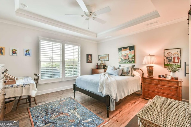 5641 Tisbury Ct, Hoschton, GA 30548 - bedroom featuring a raised ceiling, ornamental molding, a ceiling fan, and wood finished floors