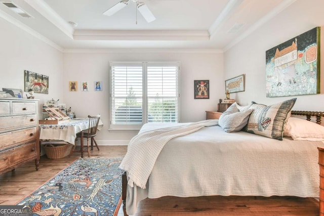 5641 Tisbury Ct, Hoschton, GA 30548 - bedroom featuring visible vents, ornamental molding, a raised ceiling, and wood finished floors