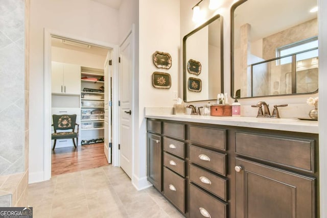 5641 Tisbury Ct, Hoschton, GA 30548 - full bathroom featuring double vanity, a walk in closet, tile patterned flooring, a shower stall, and a sink