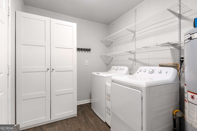 washroom with dark wood finished floors, washer and clothes dryer, and gas water heater