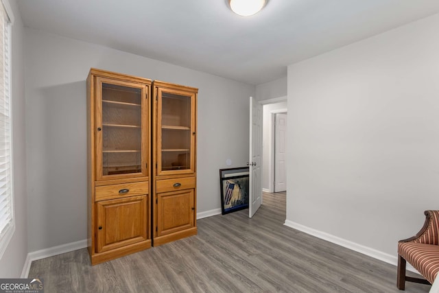 living area with baseboards and wood finished floors