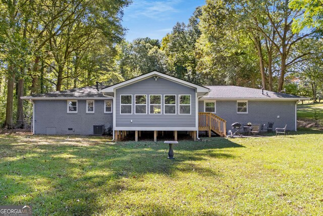 back of house with a lawn, crawl space, central AC, and brick siding