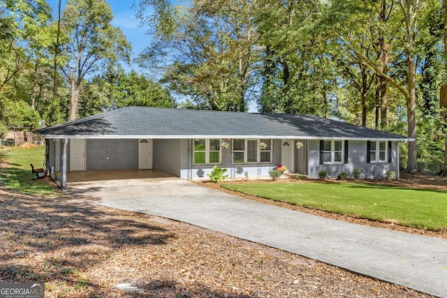 ranch-style home featuring driveway, roof with shingles, a front yard, a carport, and brick siding