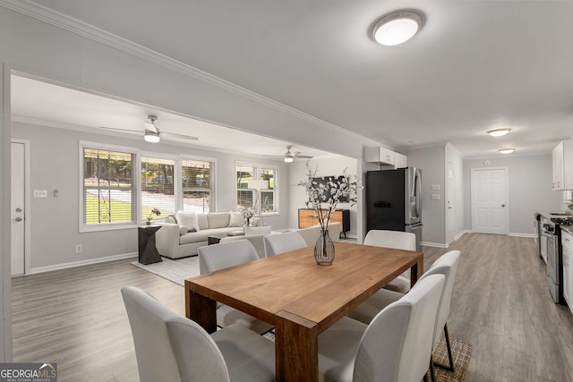 dining space with baseboards, a wealth of natural light, ceiling fan, and light wood-type flooring