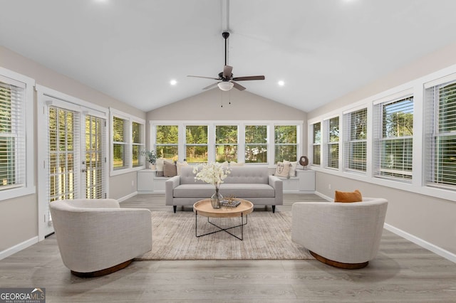 sunroom featuring baseboards, wood finished floors, and a wealth of natural light