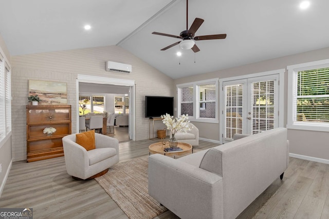living room with baseboards, a wall mounted AC, vaulted ceiling, and light wood finished floors