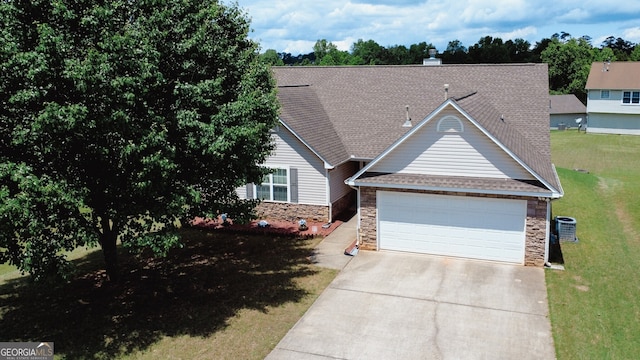 view of front of property featuring concrete driveway, a garage, stone siding, and a front yard