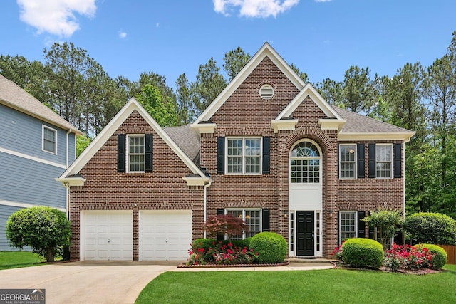 colonial-style house with driveway, brick siding, a front lawn, and a garage