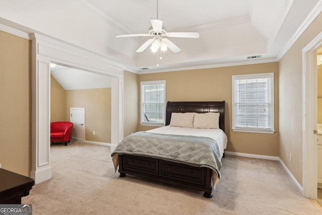 bedroom with light carpet, multiple windows, a tray ceiling, and crown molding