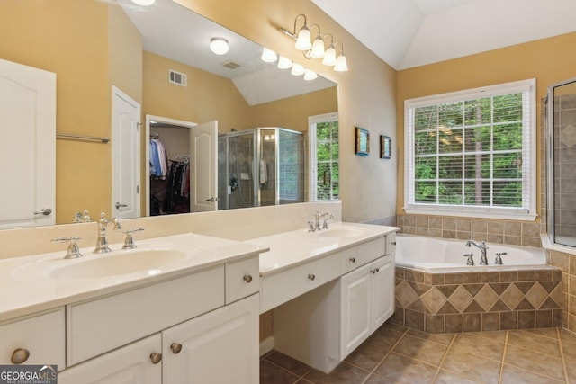 full bathroom featuring tile patterned flooring, a stall shower, lofted ceiling, double vanity, and a bath