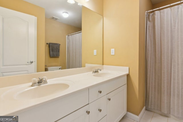 full bathroom with tile patterned floors, toilet, and double vanity