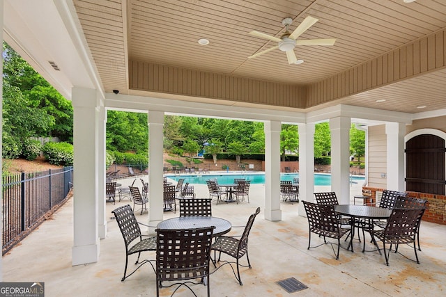 view of patio featuring fence, a community pool, and ceiling fan