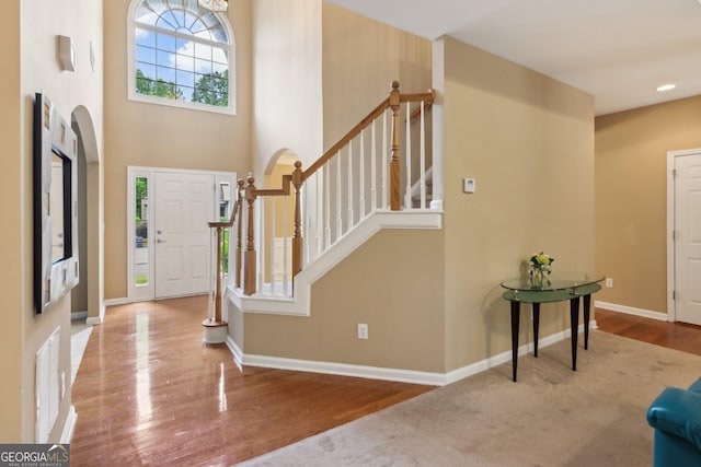 entrance foyer with wood finished floors, stairway, and baseboards