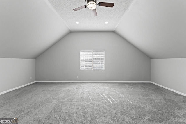 bonus room featuring carpet floors, a textured ceiling, ceiling fan, and lofted ceiling