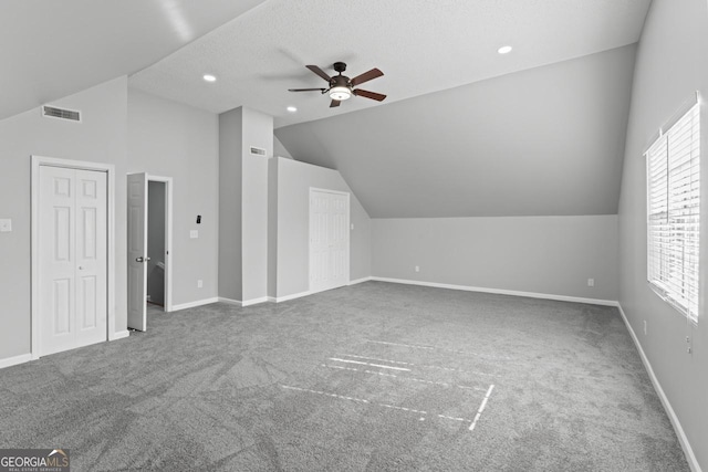 additional living space featuring ceiling fan, visible vents, carpet floors, baseboards, and lofted ceiling
