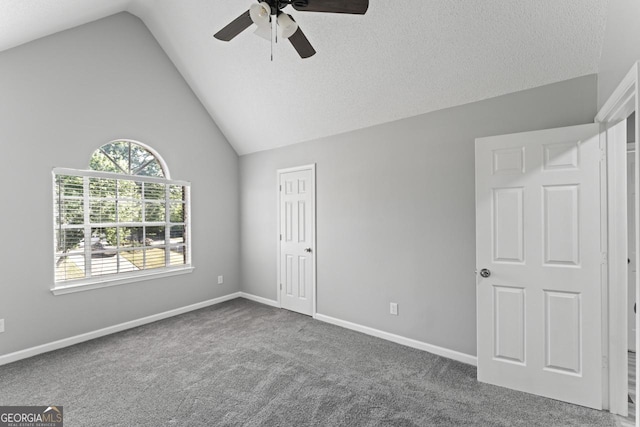 unfurnished bedroom featuring carpet flooring, baseboards, vaulted ceiling, and ceiling fan