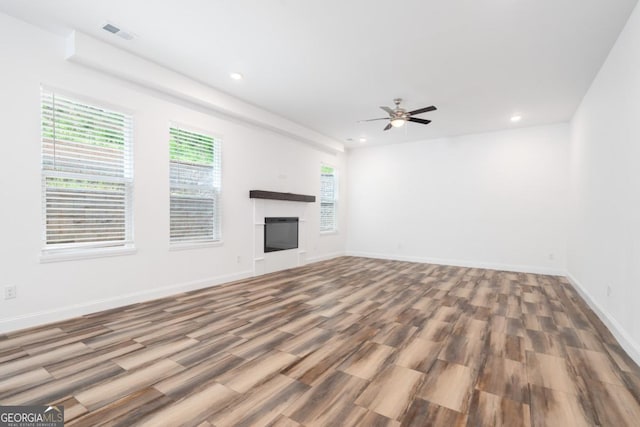 830 Dixon Dr, Gainesville, GA 30501 - unfurnished living room with visible vents, a glass covered fireplace, wood finished floors, recessed lighting, and a ceiling fan