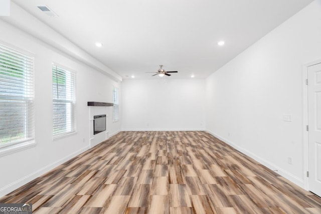 830 Dixon Dr, Gainesville, GA 30501 - unfurnished living room with a fireplace, a ceiling fan, wood finished floors, and visible vents