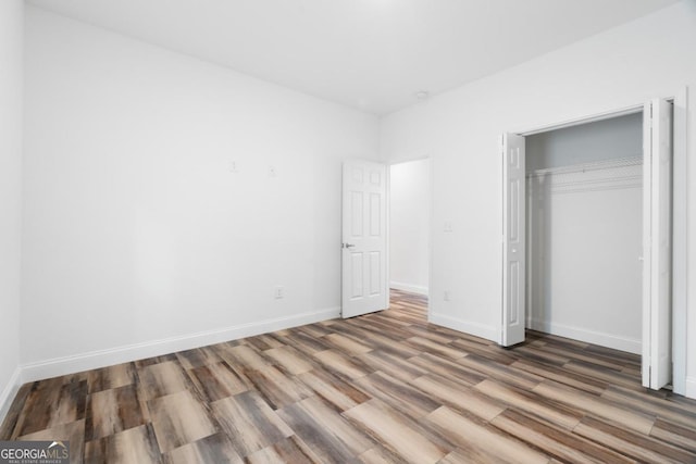 830 Dixon Dr, Gainesville, GA 30501 - unfurnished bedroom featuring a closet, baseboards, and wood finished floors