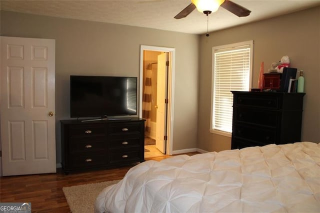 bedroom with baseboards, ensuite bathroom, wood finished floors, and multiple windows