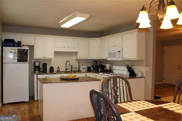 kitchen featuring white appliances, dark wood-type flooring, white cabinets, tasteful backsplash, and a sink