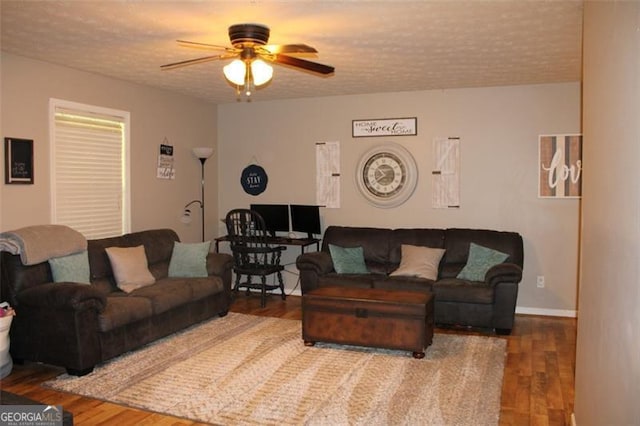 living room featuring a ceiling fan, a textured ceiling, and wood finished floors