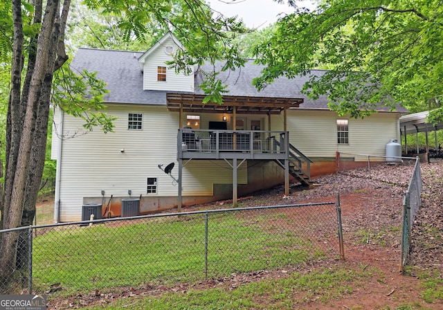 rear view of property with a wooden deck, a fenced backyard, central AC unit, a shingled roof, and stairway