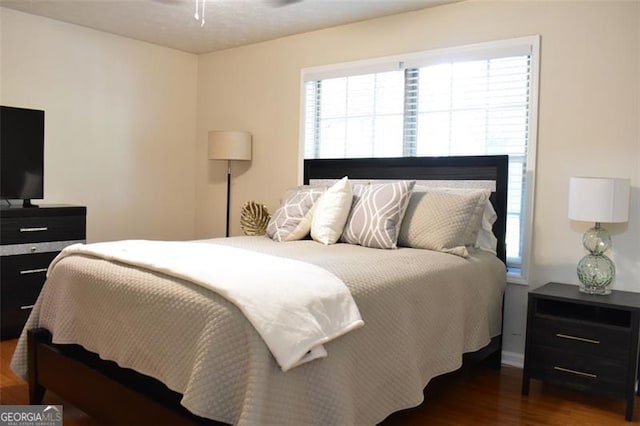 bedroom featuring baseboards and wood finished floors