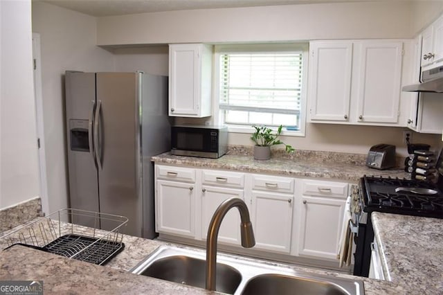 kitchen with a sink, stainless steel appliances, white cabinetry, and under cabinet range hood