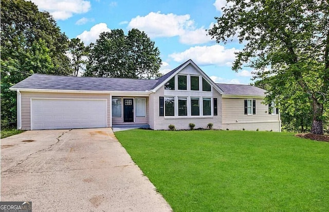 ranch-style home featuring an attached garage, concrete driveway, and a front yard