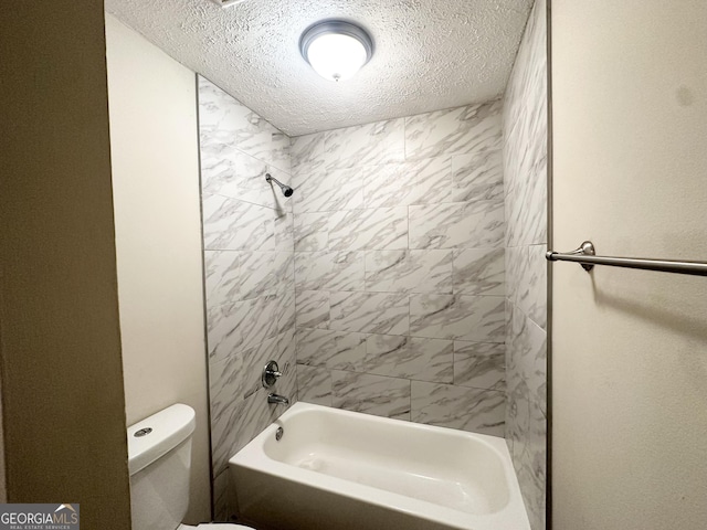 bathroom featuring shower / bathtub combination, toilet, and a textured ceiling
