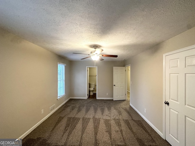 unfurnished bedroom featuring carpet floors, baseboards, a textured ceiling, and visible vents