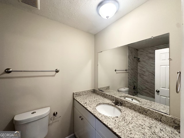full bath with visible vents, vanity, bathing tub / shower combination, toilet, and a textured ceiling