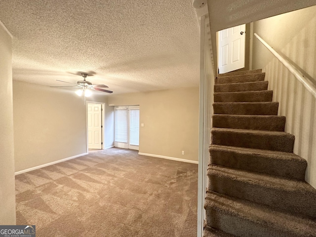 stairs featuring carpet floors, a ceiling fan, a textured ceiling, and baseboards