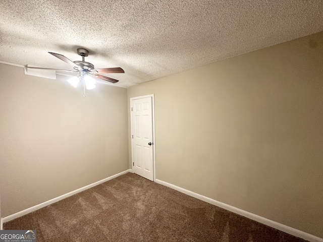 spare room featuring a ceiling fan, baseboards, a textured ceiling, and dark colored carpet