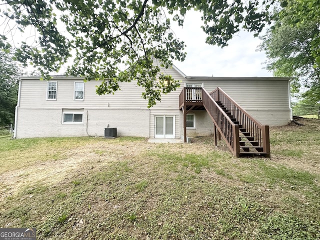 rear view of house featuring a deck, brick siding, central air condition unit, a yard, and stairway