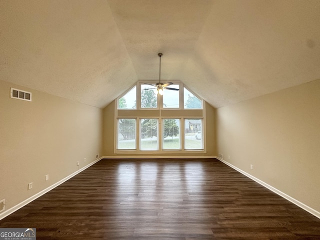 bonus room featuring dark wood-style flooring, a ceiling fan, baseboards, vaulted ceiling, and visible vents