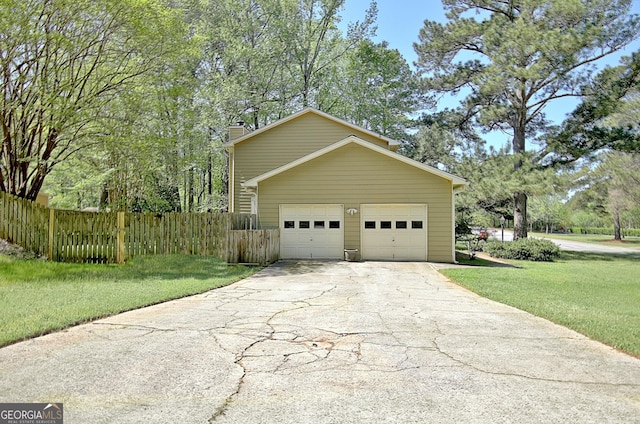 view of side of property with a lawn, fence, driveway, and a chimney