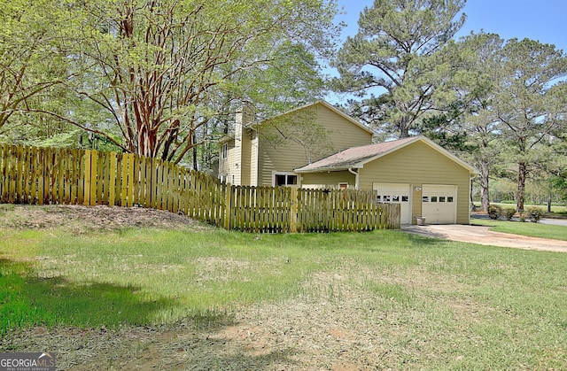 view of home's exterior featuring concrete driveway, a lawn, fence, and a garage