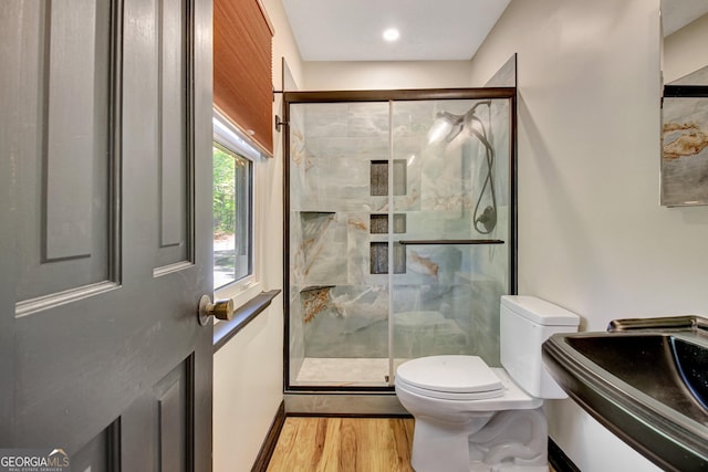 full bathroom featuring vanity, toilet, baseboards, a shower stall, and wood finished floors