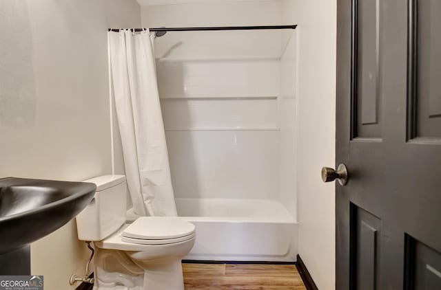 full bathroom with toilet, wood finished floors, and shower / bath combo
