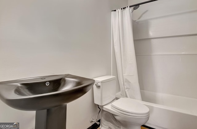 bathroom with shower / bath combo with shower curtain and toilet