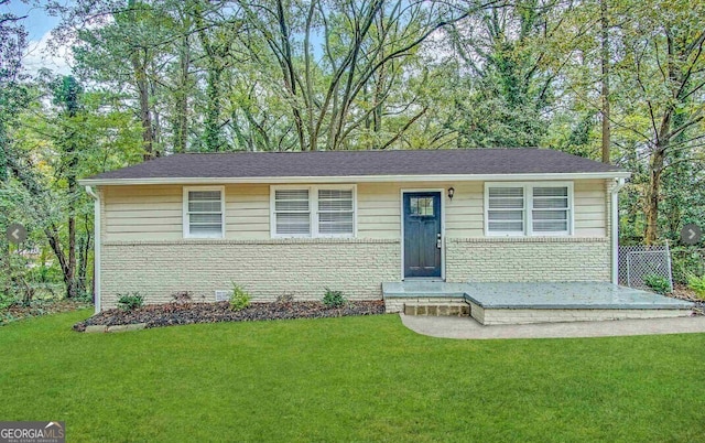 ranch-style house with a front yard and brick siding