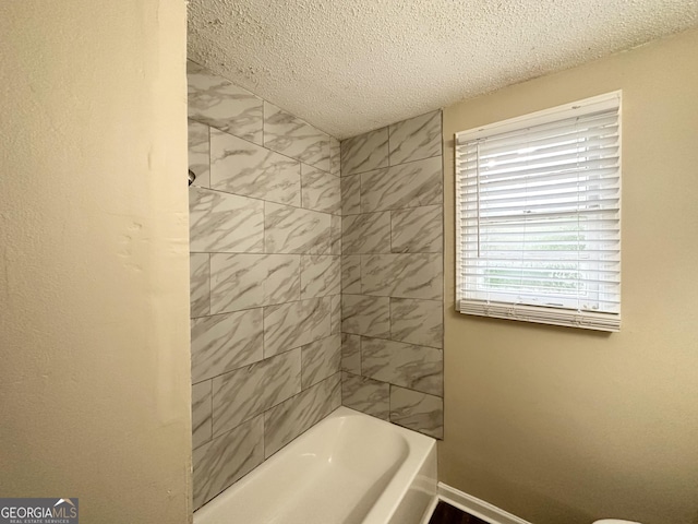 bathroom with baseboards, a textured ceiling, and  shower combination