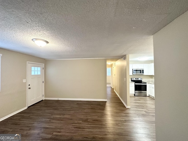 foyer entrance with baseboards, a textured ceiling, and dark wood-type flooring