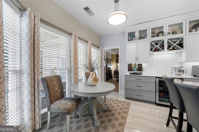 dining room featuring visible vents, a dry bar, and wine cooler